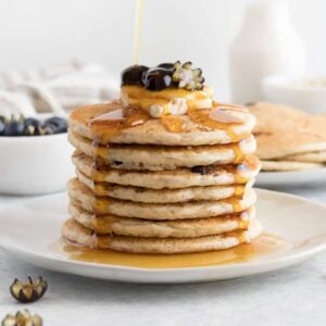 maple syrup poured onto blueberry pancakes