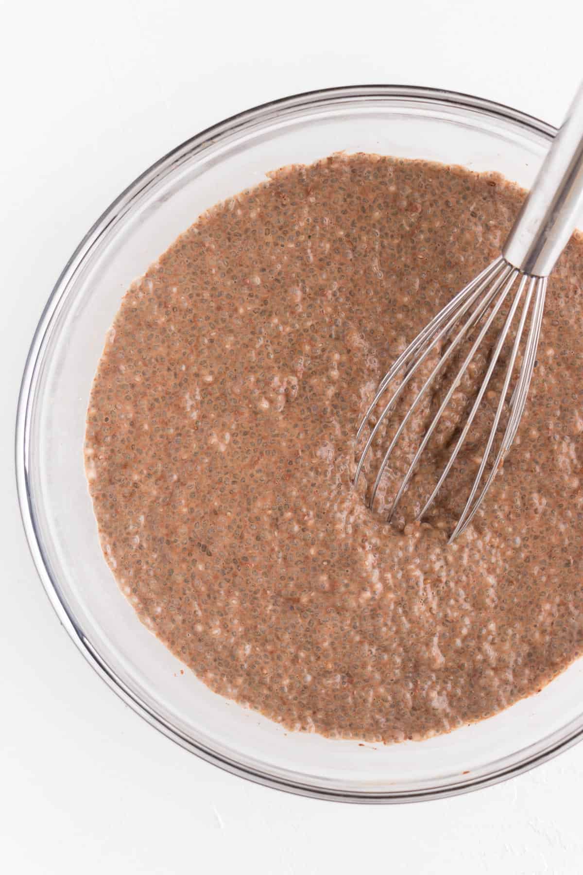 chocolate chia pudding in a bowl with a whisk