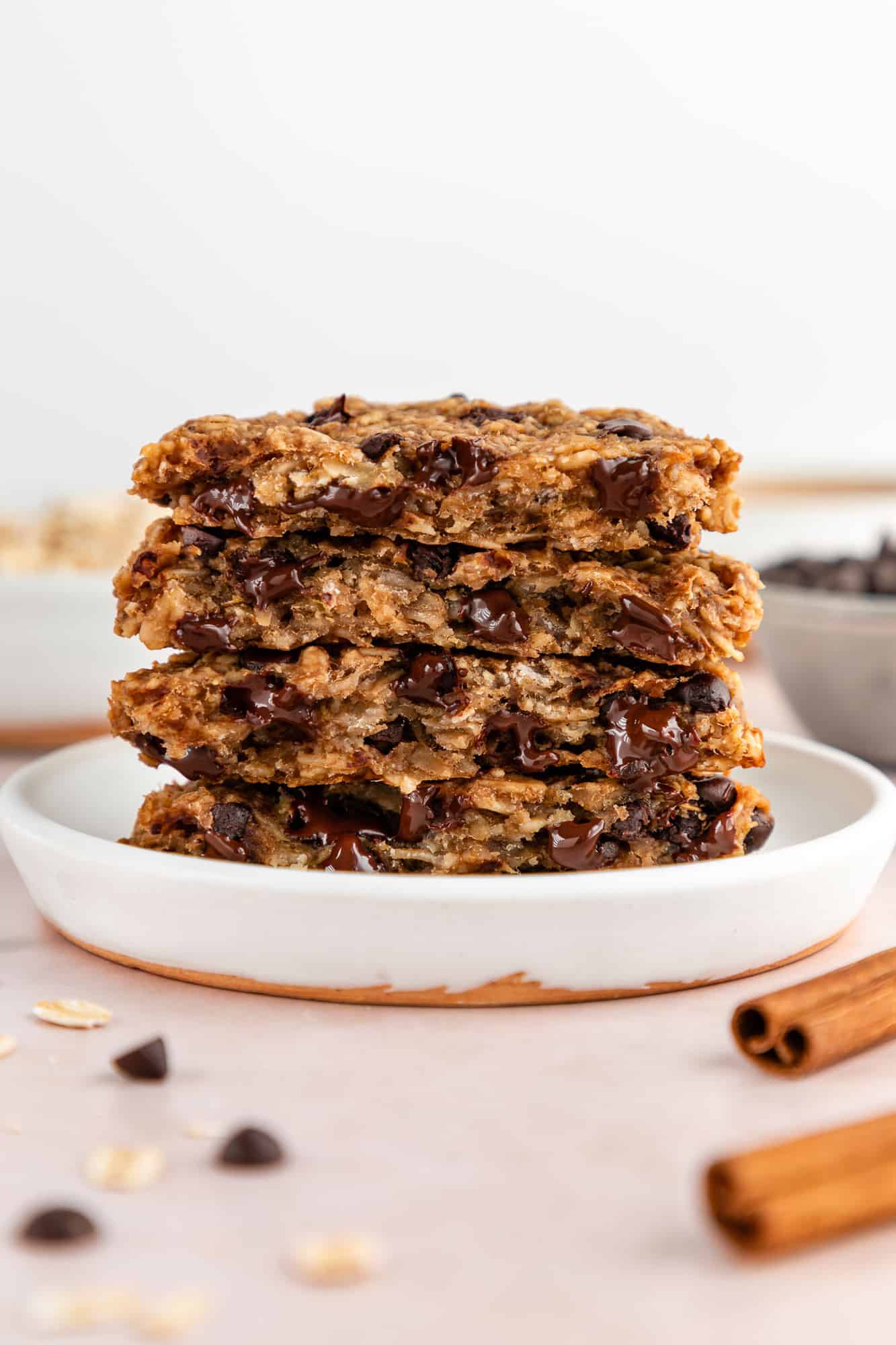 a stack of peanut butter banana oatmeal cookies with chocolate chips on a small white plate