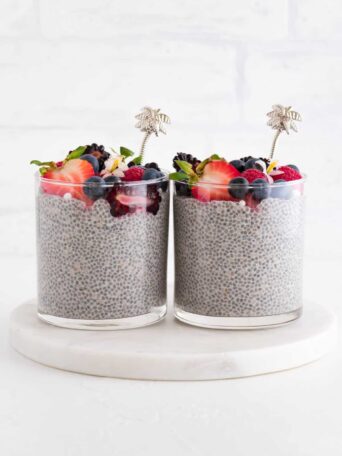 two glasses of vanilla chia pudding with fruit on top
