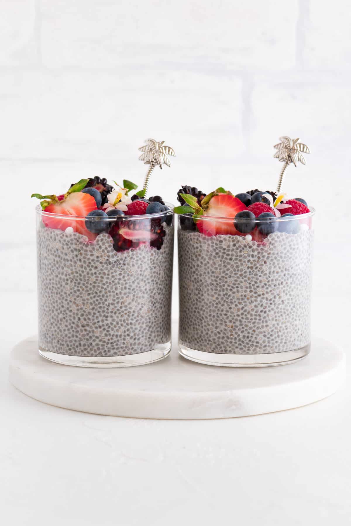 two glasses of vanilla chia pudding with fruit on top