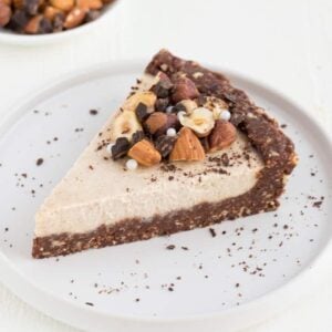 a slice of raw vegan chocolate almond cheesecake on a small white plate