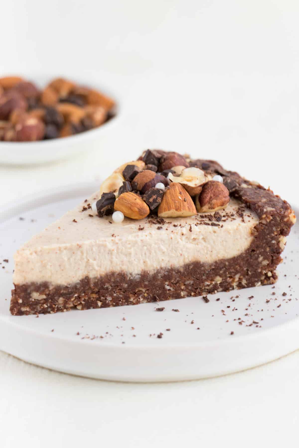 no bake chocolate almond cheesecake slice sitting on top of a small white plate