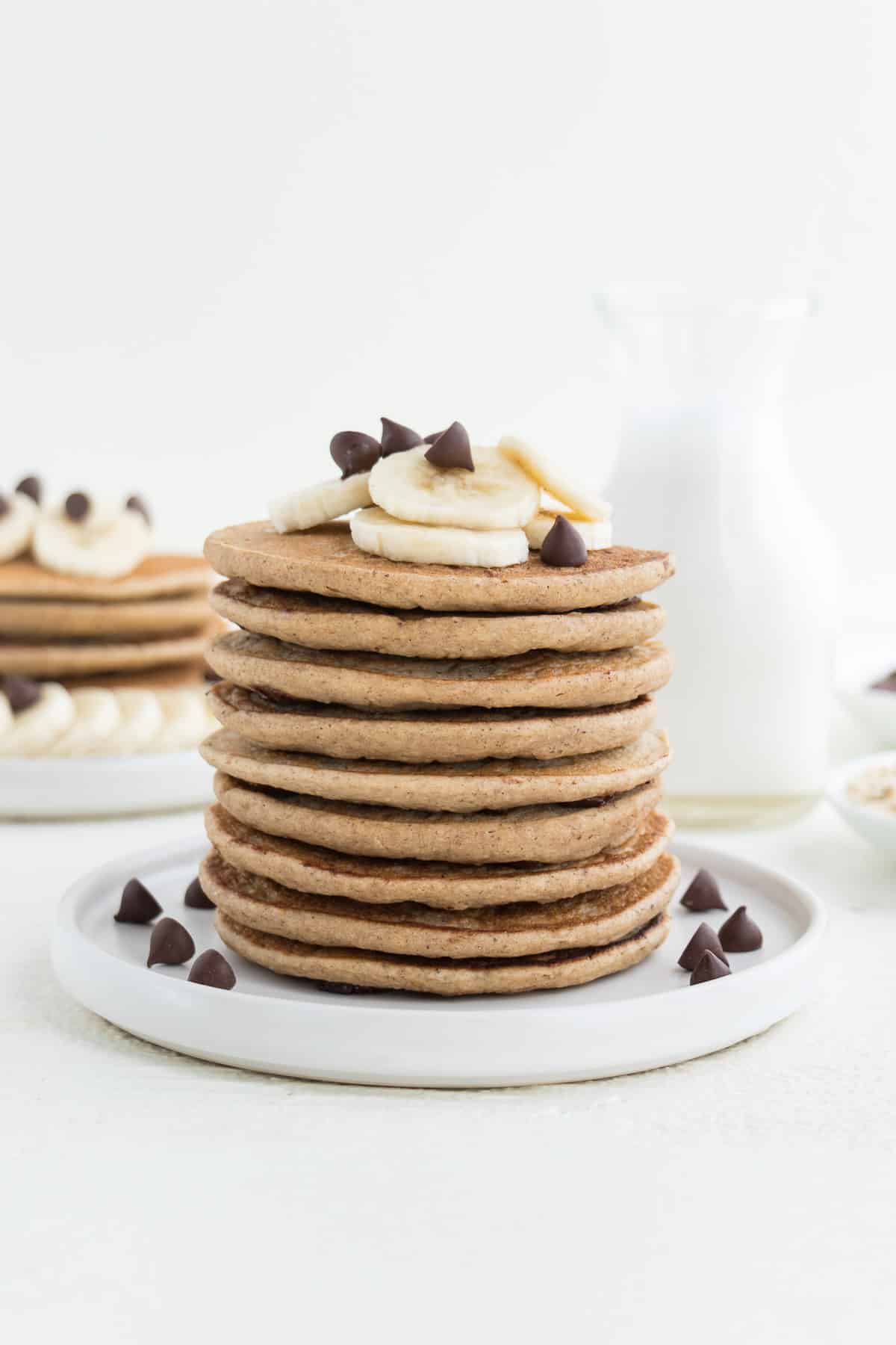 a stack of banana pancakes topped with chocolate chips and sliced banana