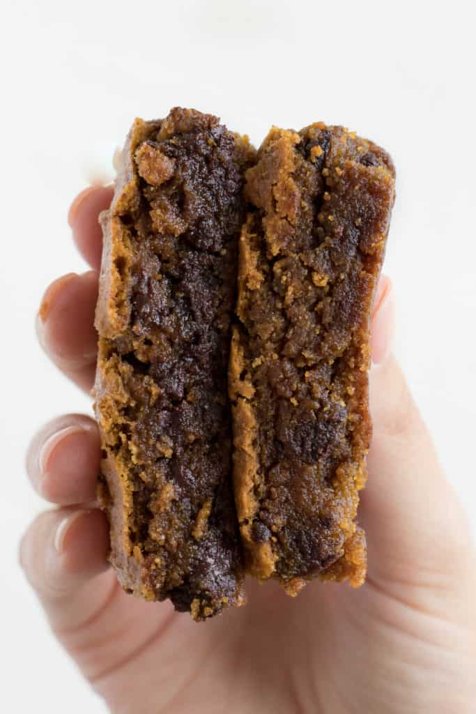 a hand holding two gooey pumpkin blondies