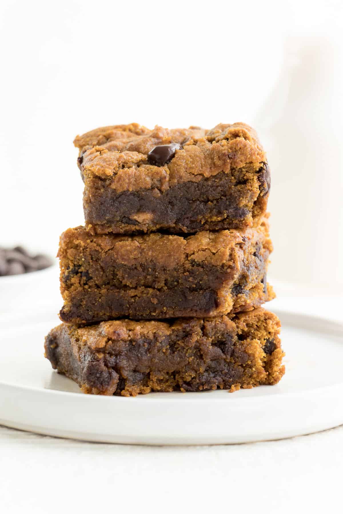 chocolate chip pumpkin bars stacked on a small white plate