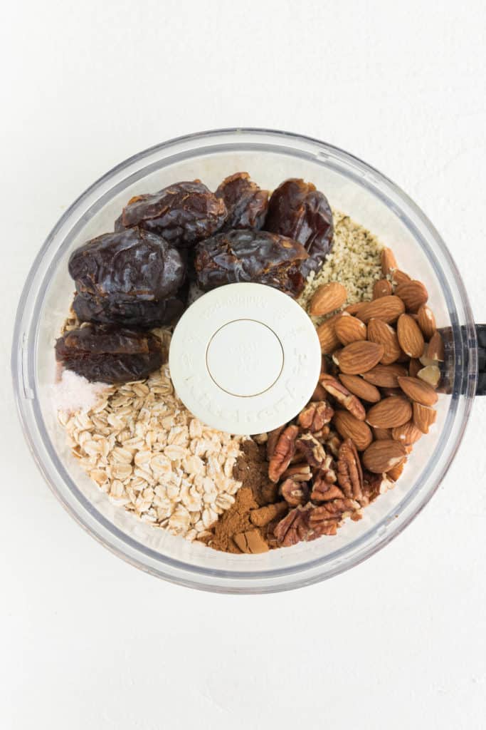 medjool dates, almonds, pecans, rolled oats, and hemp seeds inside a food processor