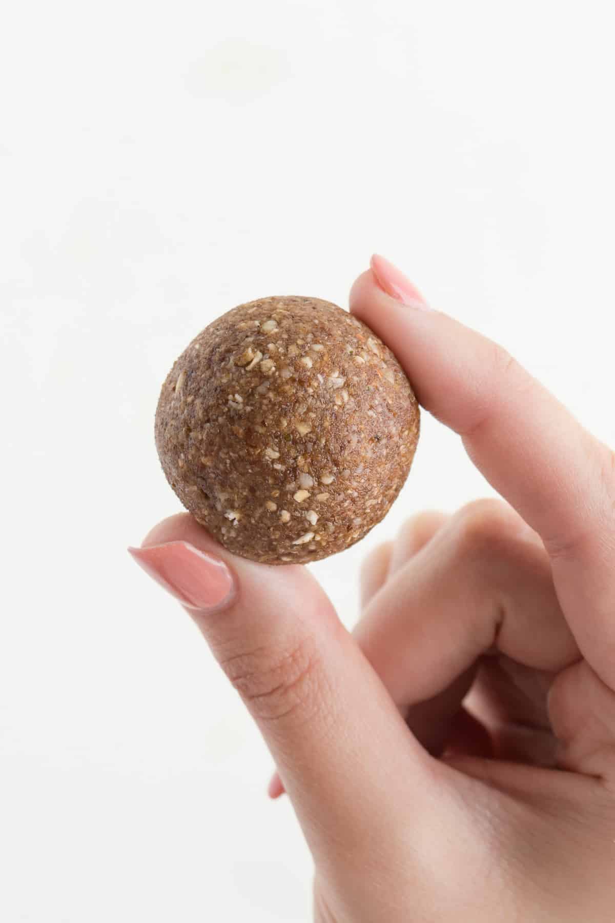 a hand holding a no-bake pecan pie bliss ball