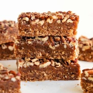 a stack of three pecan pie bars on top of a white marble surface