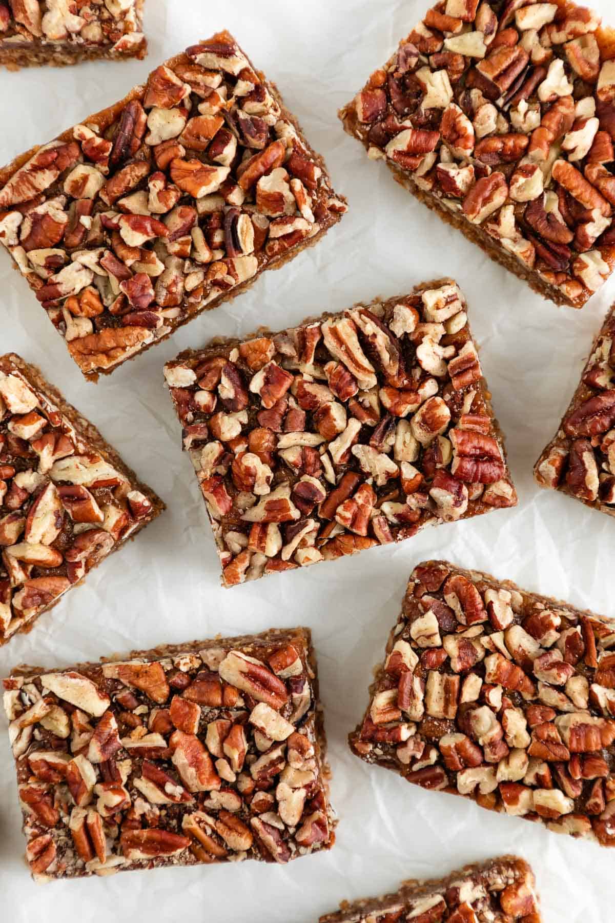 5 vegan gluten-free pecan pie bars on top of a white surface