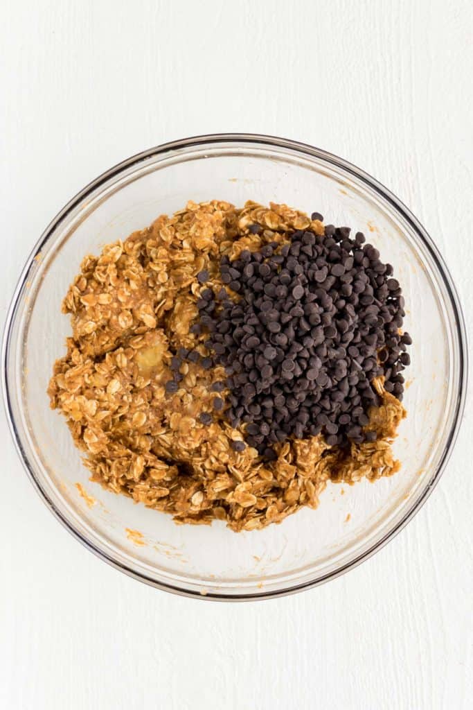 mini vegan chocolate chips and pumpkin cookie batter inside a glass bowl