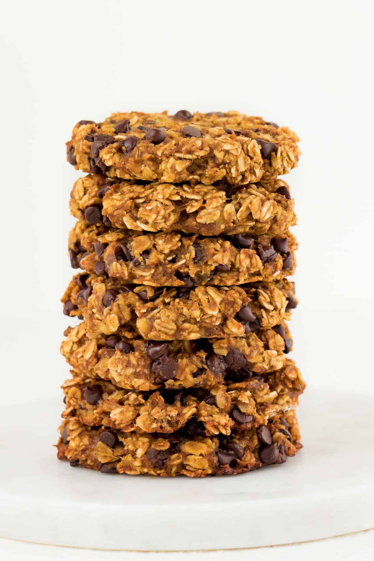 seven oatmeal chocolate chip pumpkin cookies stacked on top of each other