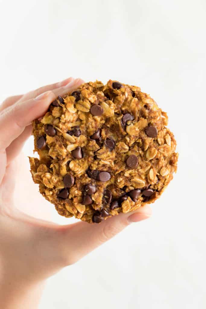 hand holding a pumpkin chocolate chip oatmeal cookie