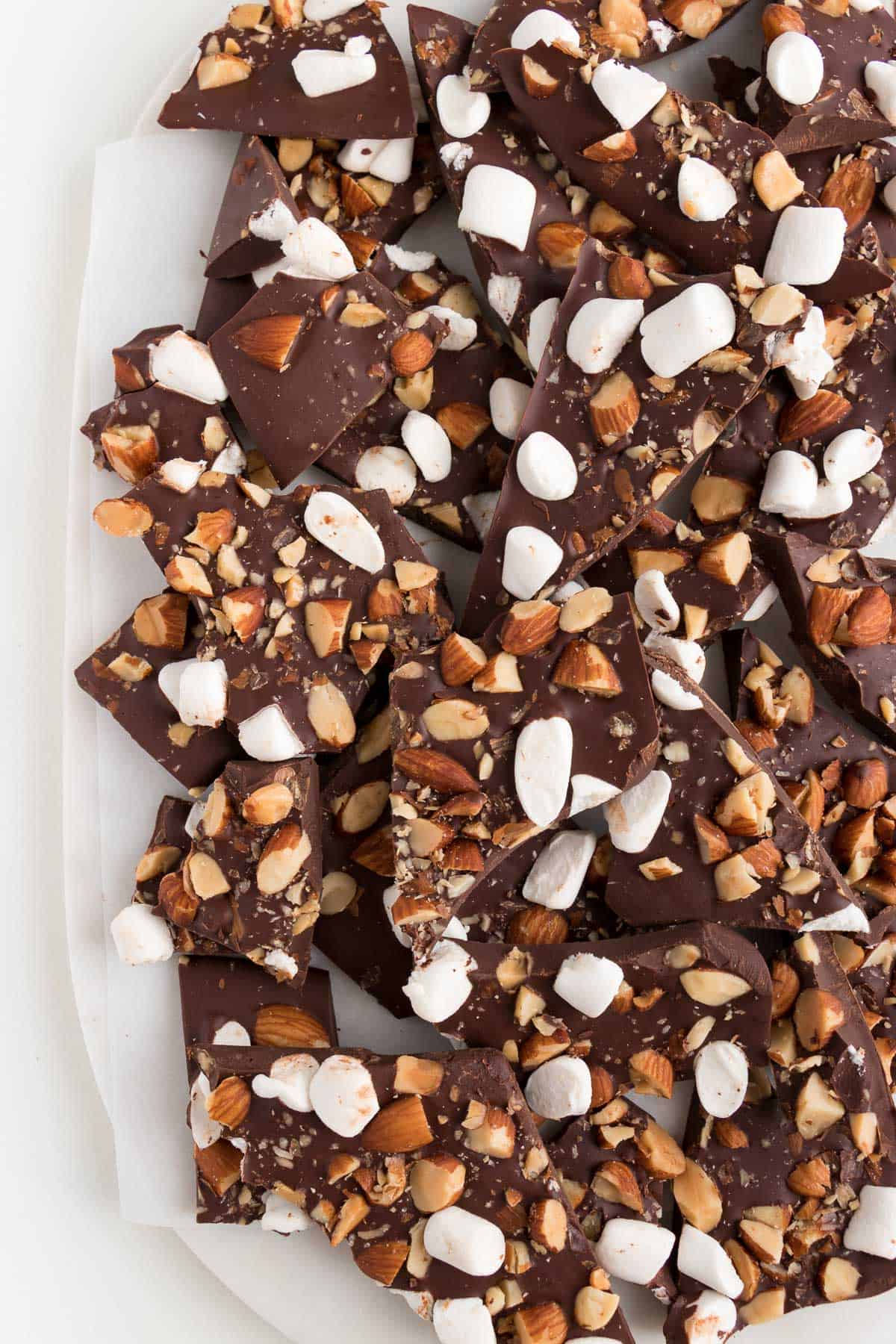 several pieces of rocky road chocolate bark on top of a white marble board