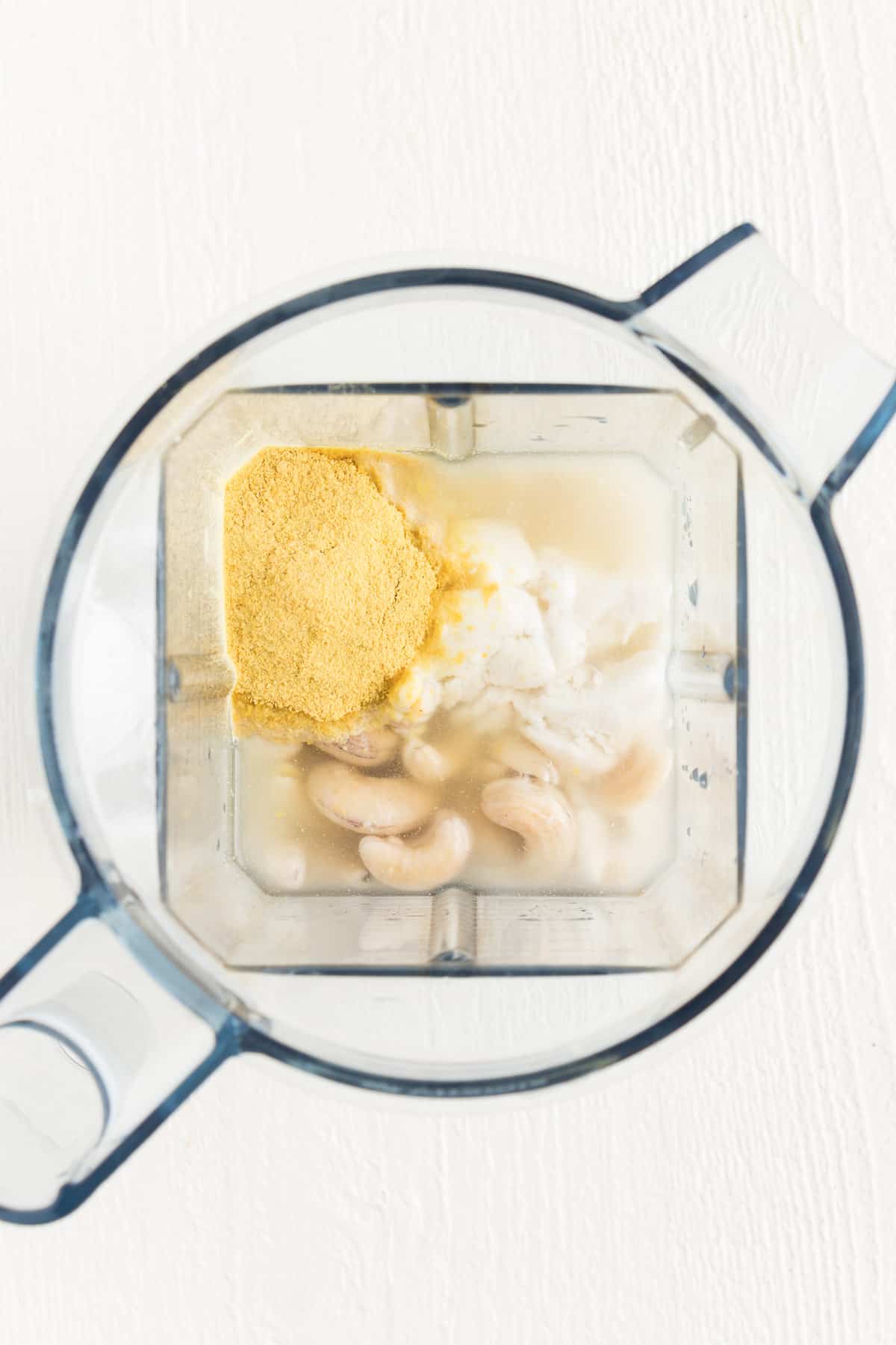 water, nutritional yeast, nondairy yogurt, and cashews inside a vitamix blender