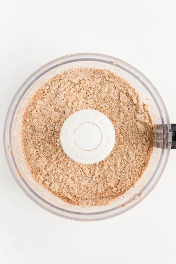 light tan crumbled flour inside a food processor