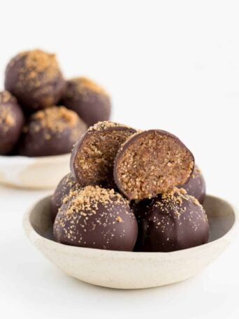 two cream and white ceramic bowls containing chocolate gingerbread truffles