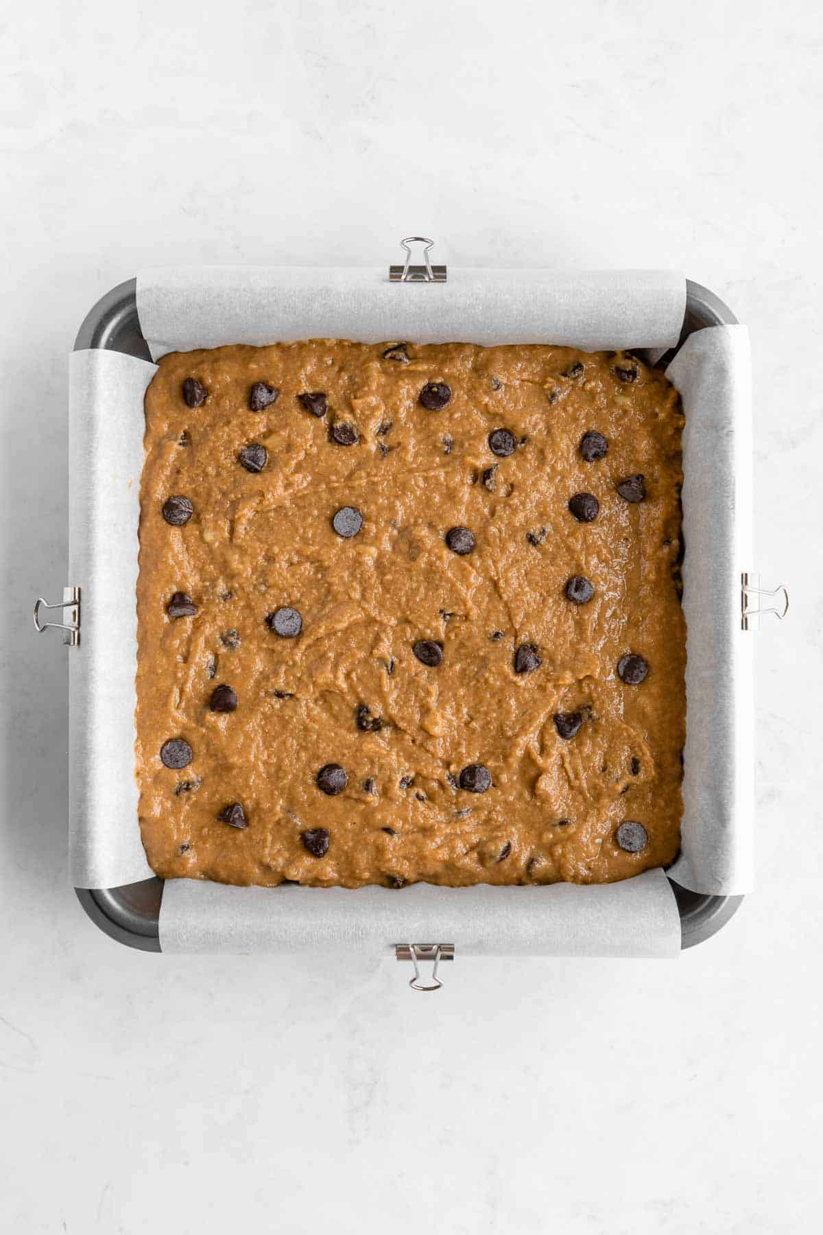 vegan gluten-free chocolate chip banana blondies batter in a square baking dish