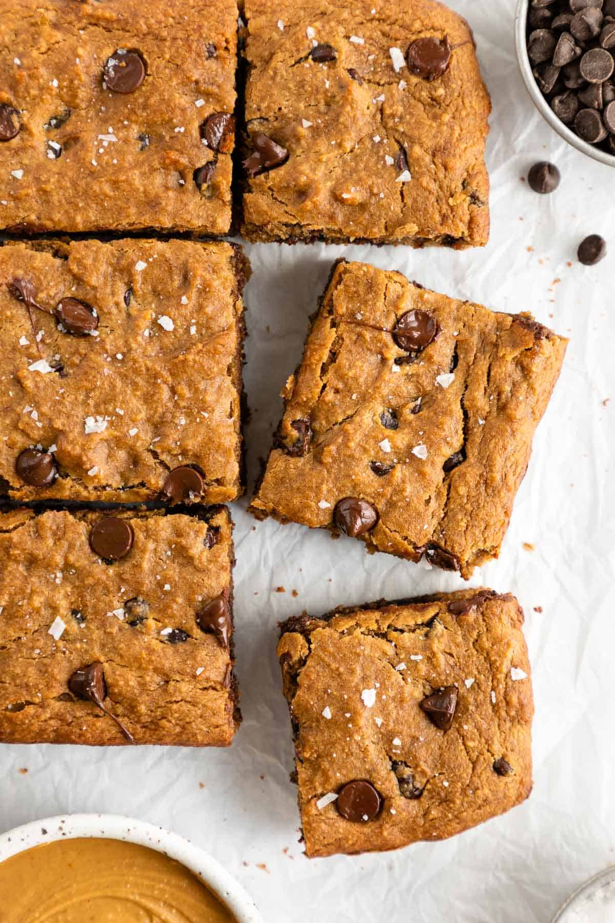 vegan gluten-free chocolate chip banana blondie bars on white parchment paper