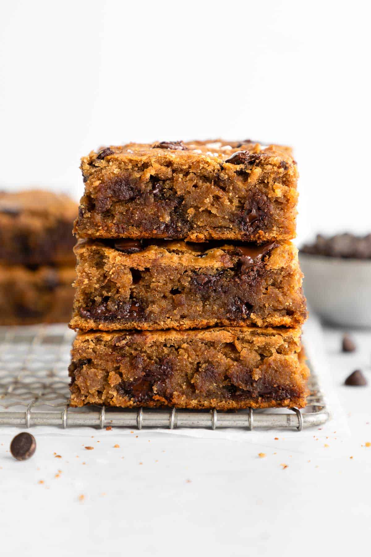 a stack of three chocolate chip banana blondies bars on a wire rack
