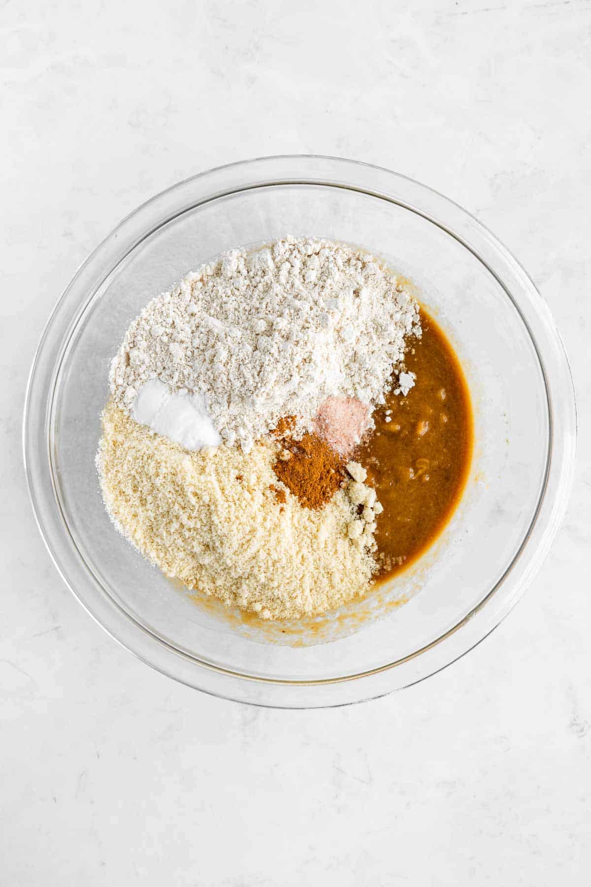 almond flour and oat flour on top of blondie batter in a glass bowl