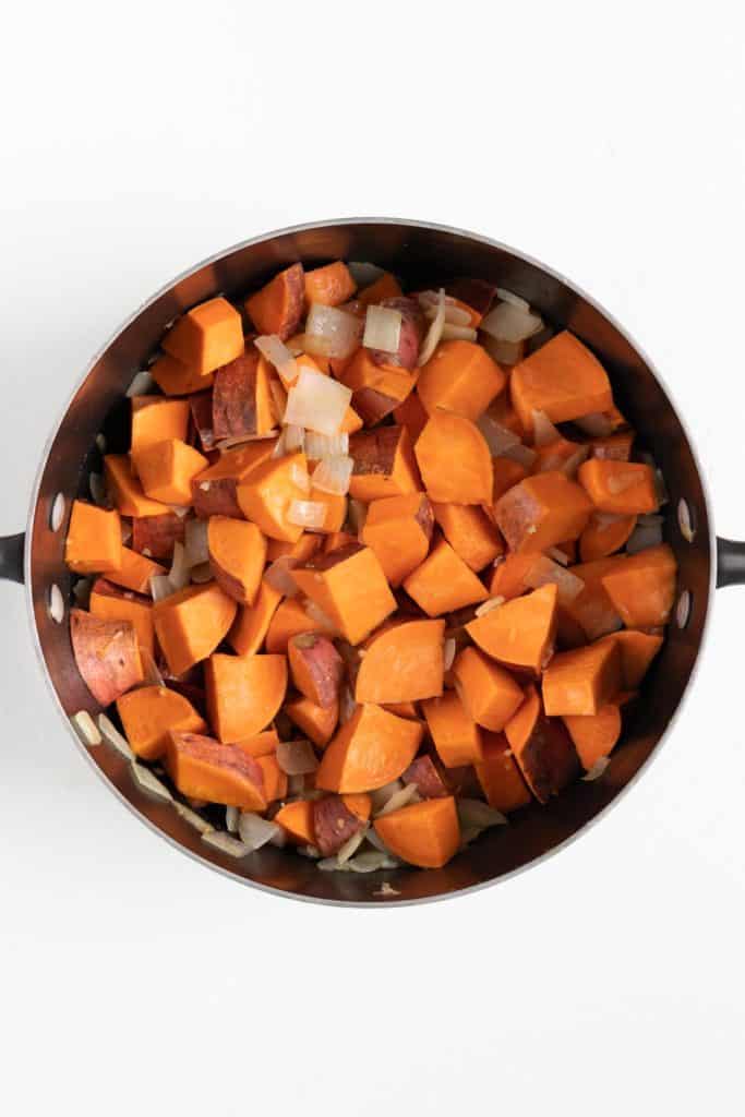 cubed sweet potatoes inside a black sauce pot