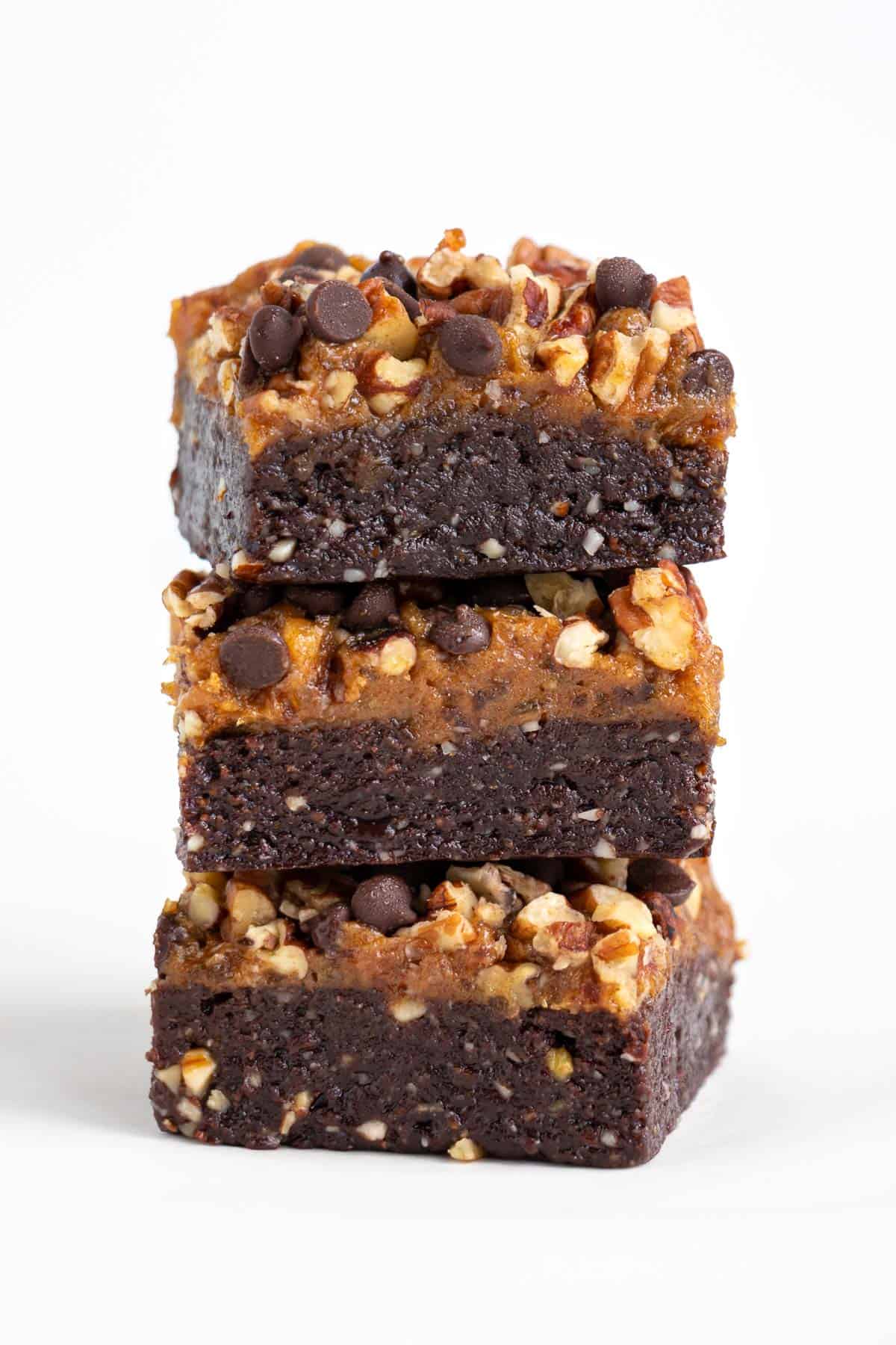 three no bake raw turtle brownies stacked on top of each other
