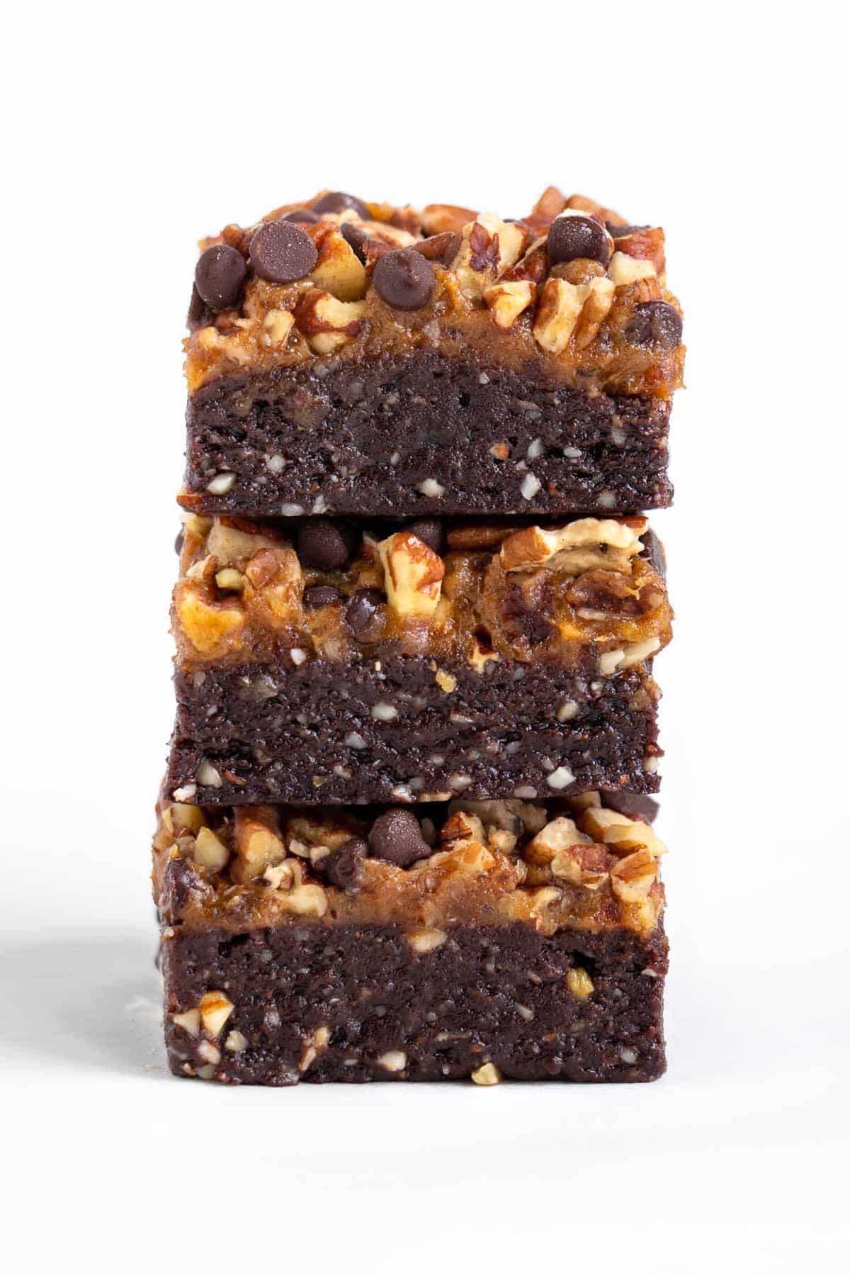 three no bake raw turtle brownies stacked on top of each other