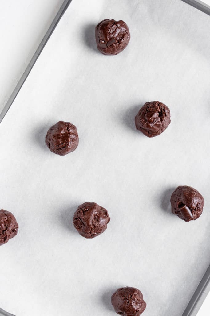 balls of double chocolate chunk cookie dough on a baking sheet