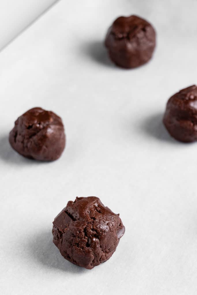 balls of double chocolate chunk cookie dough on a baking sheet