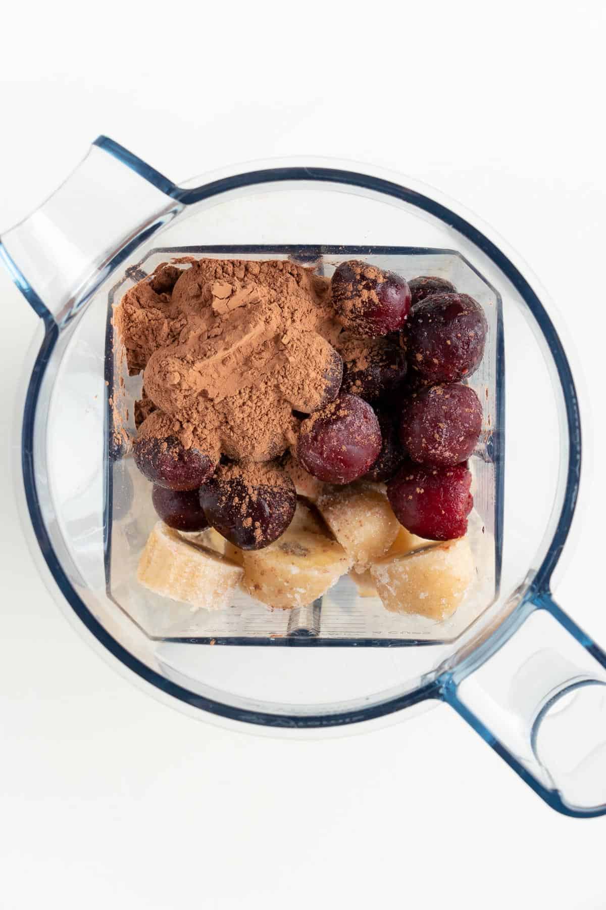 cocoa powder, chopped bananas, sliced cherries, and almond milk inside a blender