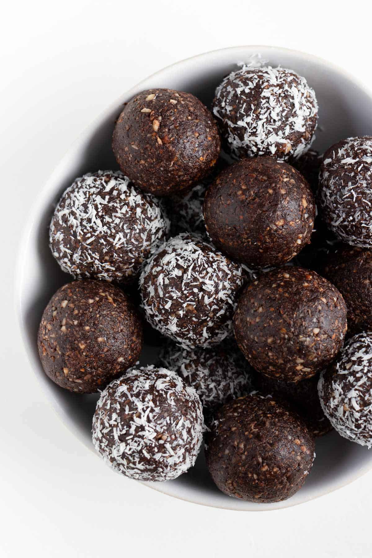 chocolate coconut energy balls inside a white bowl