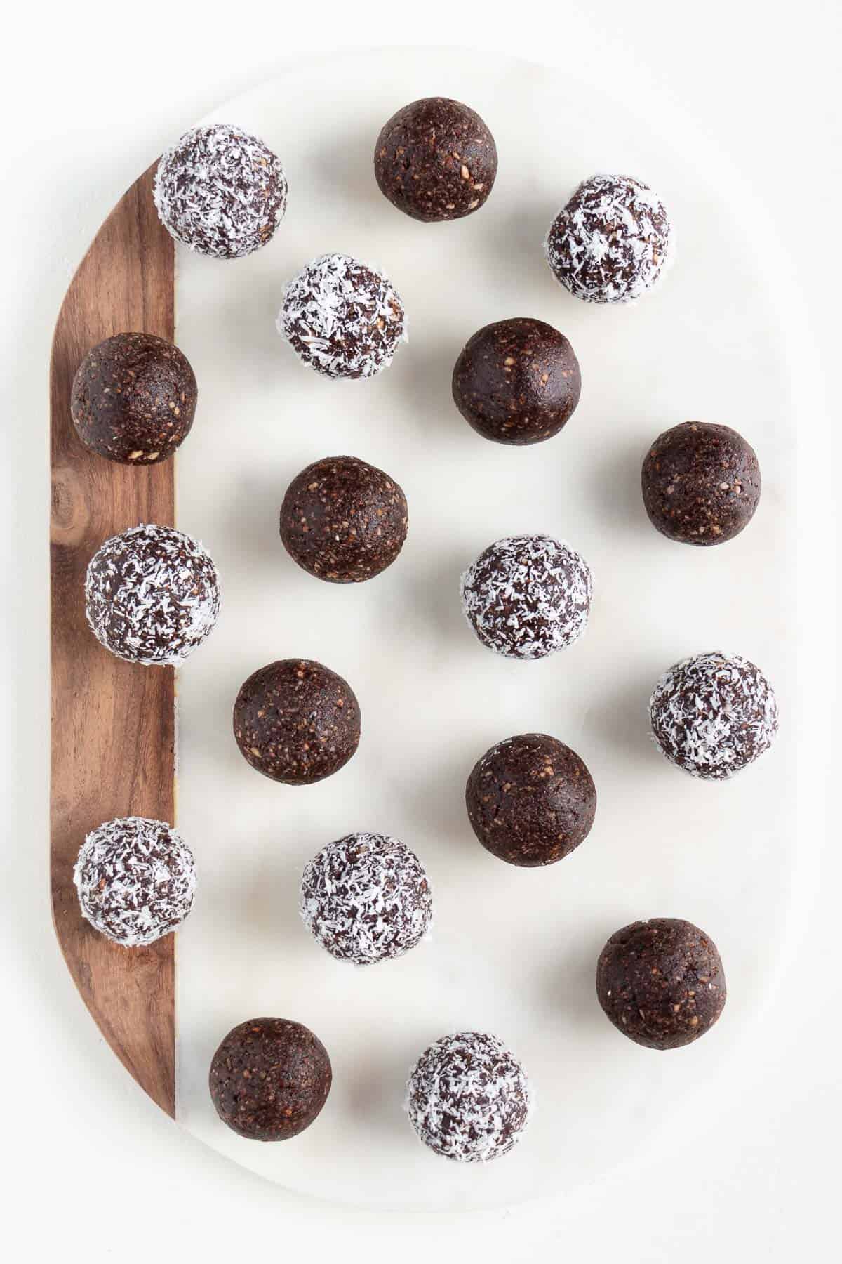 chocolate coconut energy balls on a white marble board