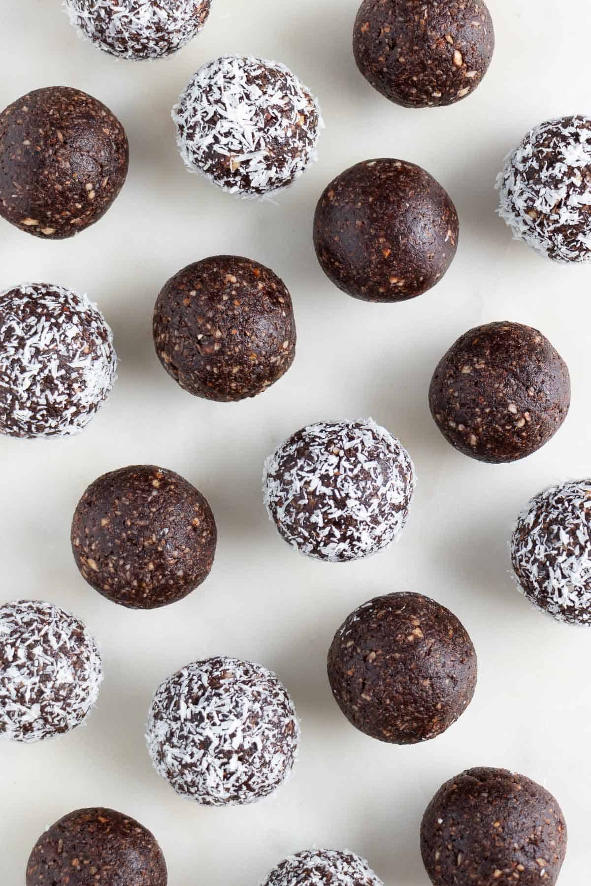 coconut chocolate date balls on a white surface