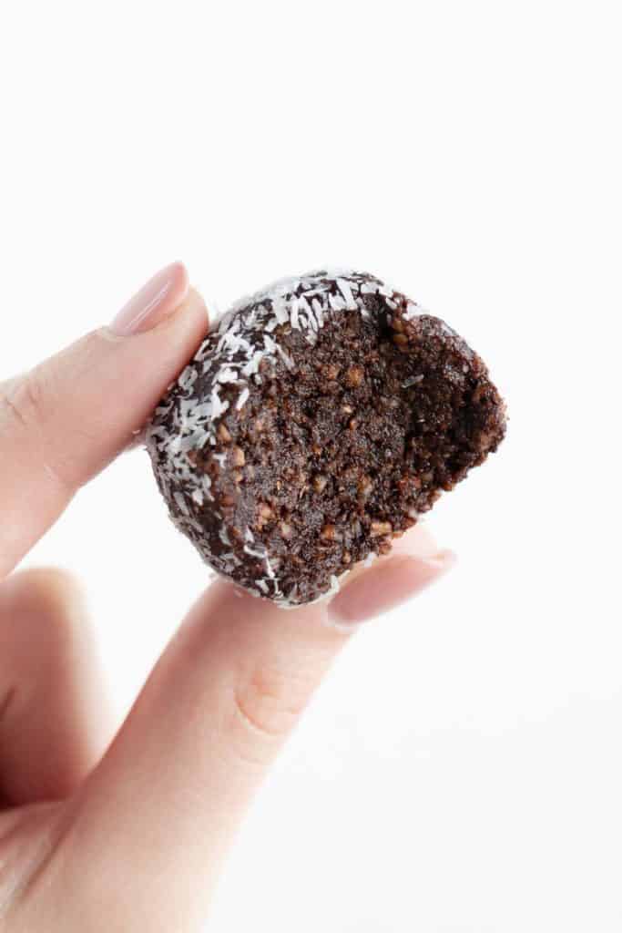 a hand holding a cacao date bite