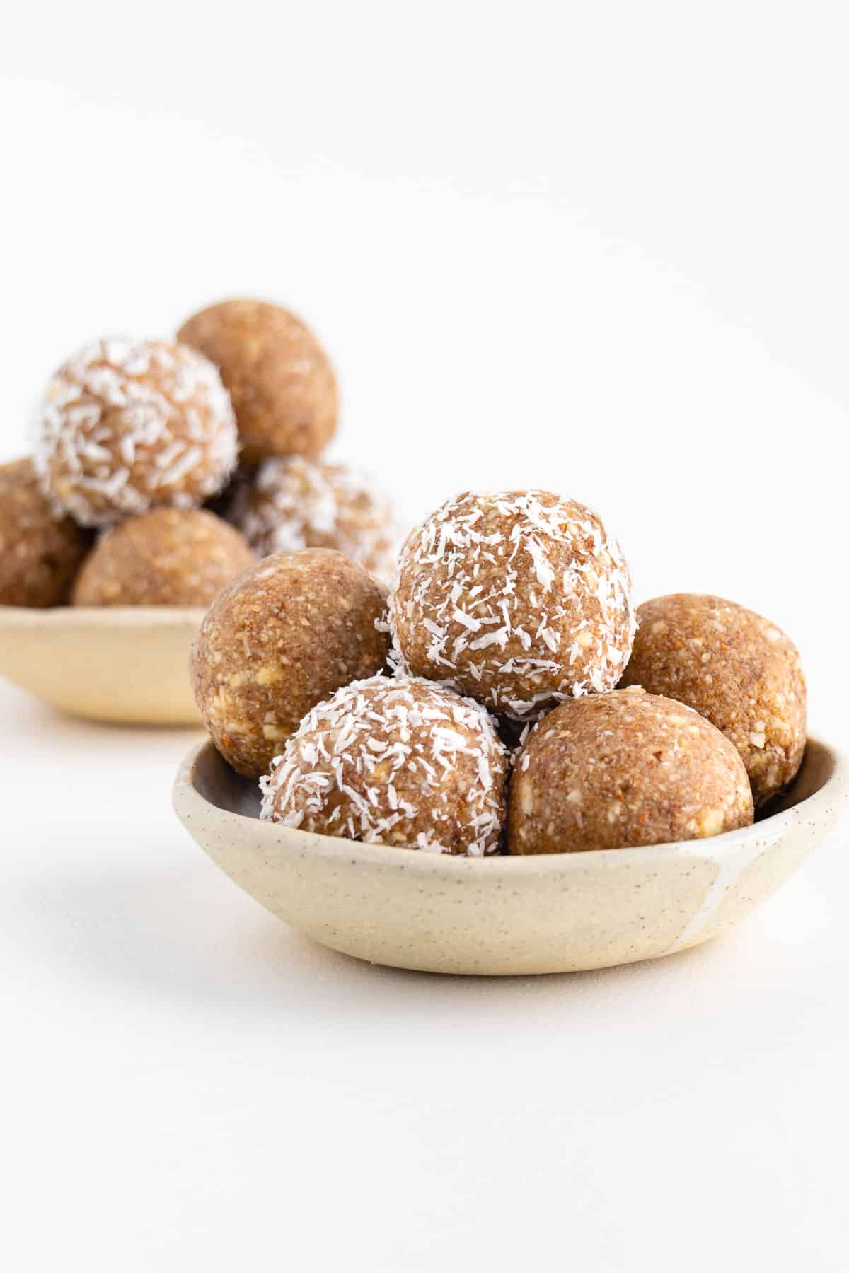 two ceramic bowls filled with coconut almond bliss balls