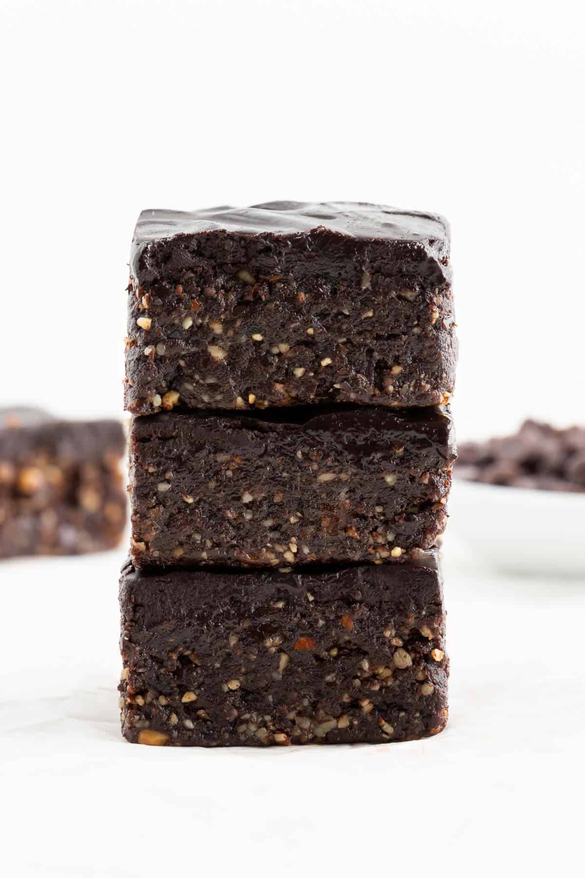 a stack of three no bake vegan brownies with chocolate ganache