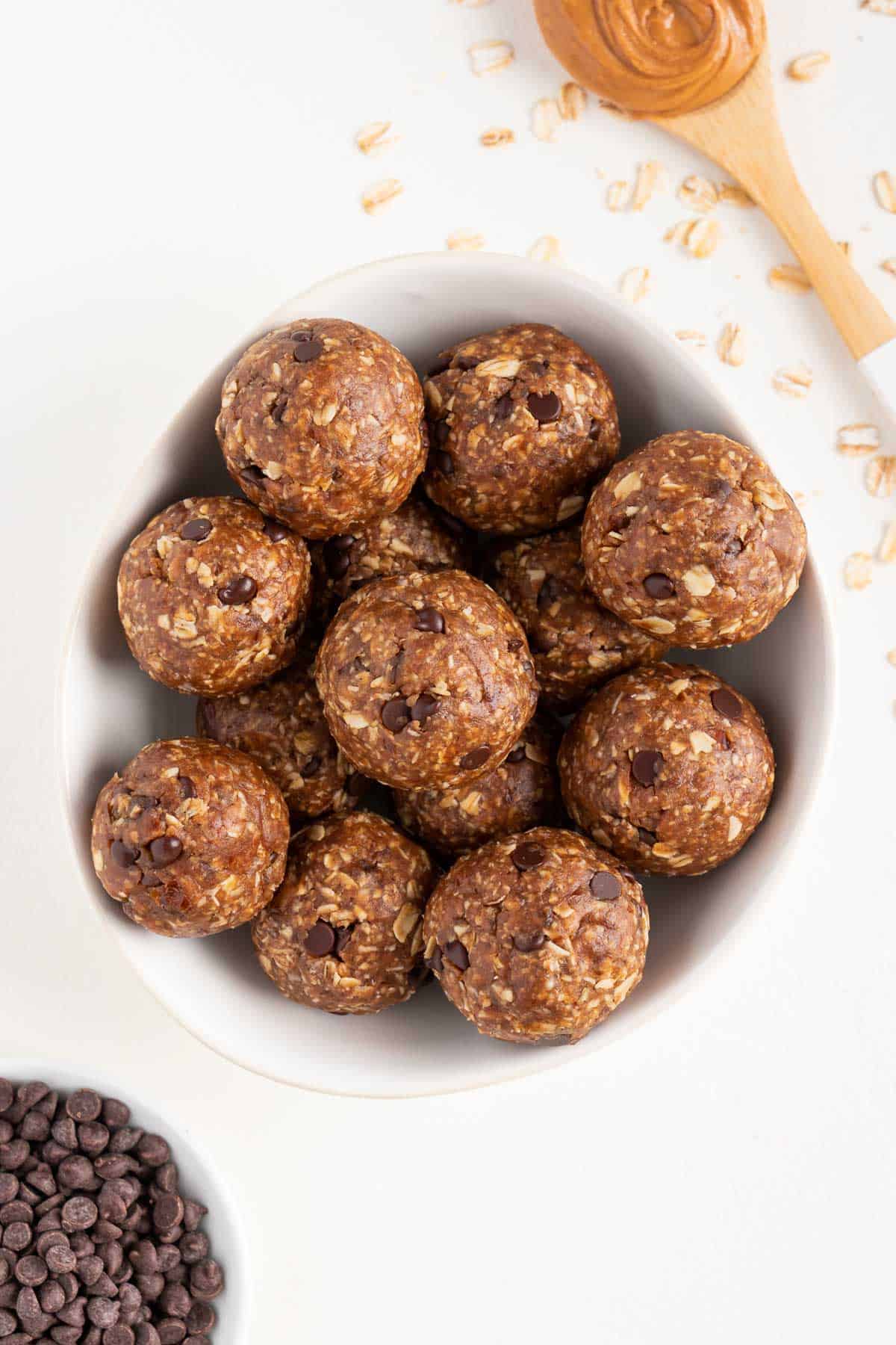 a stack of oatmeal cookie dough balls in a white bowl