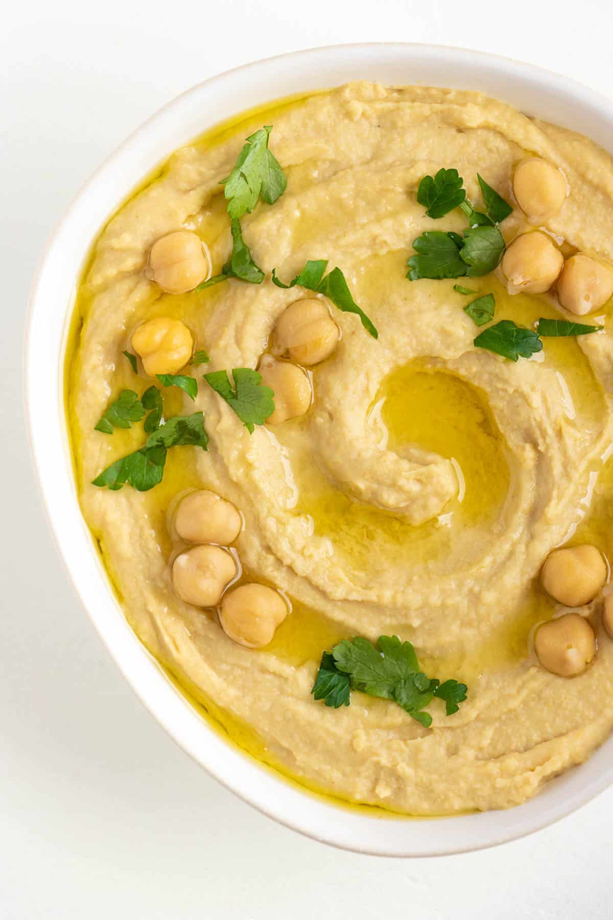 roasted garlic hummus with garbanzo beans, parsley, and olive oil on top