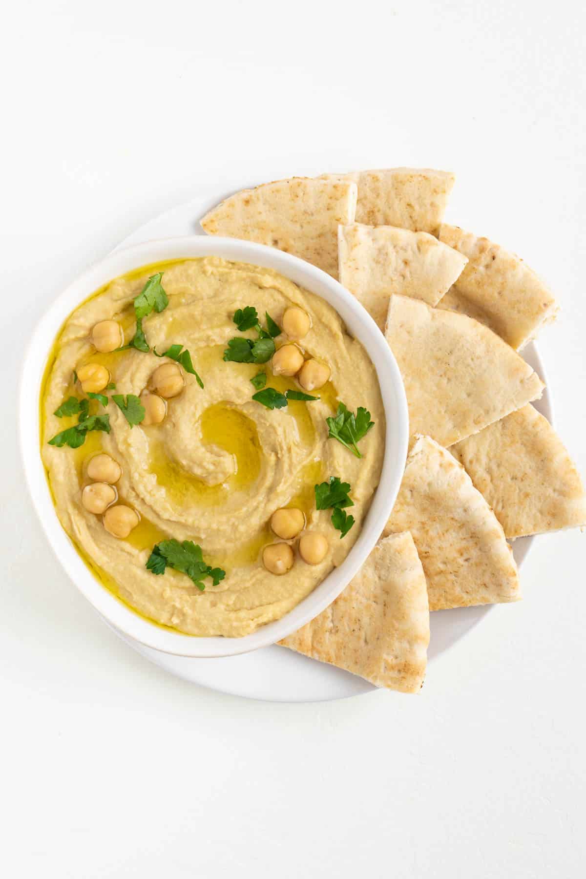 roasted garlic hummus surrounded by sliced pita bread