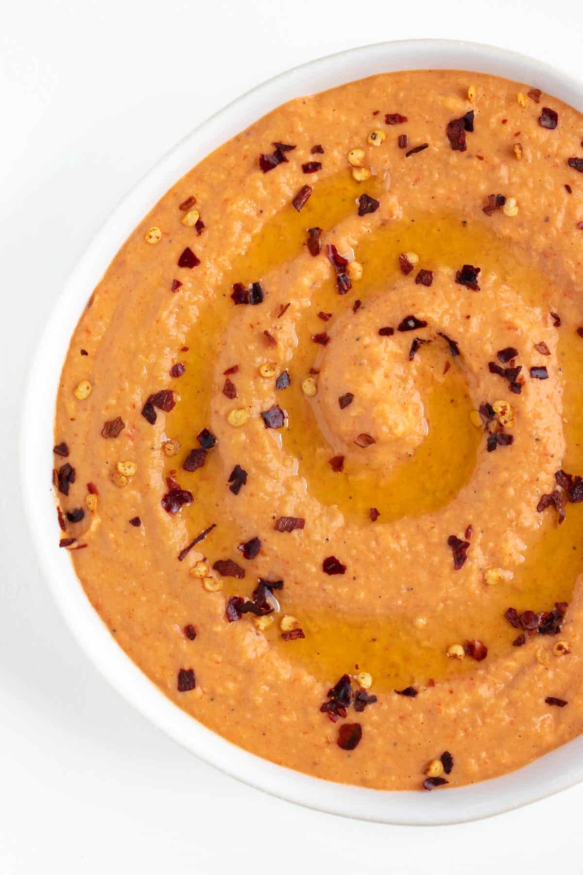 red pepper hummus topped with crushed red pepper flakes