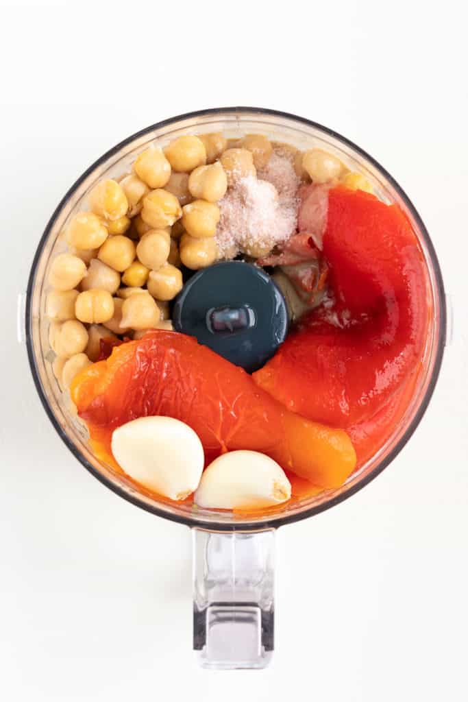 garbanzo beans, garlic, vegetables, and salt inside a food processor