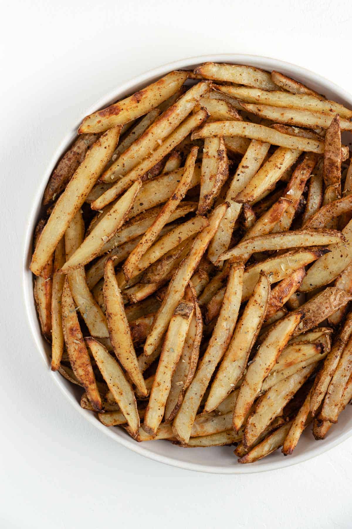 crispy baked french fries in a white bowl