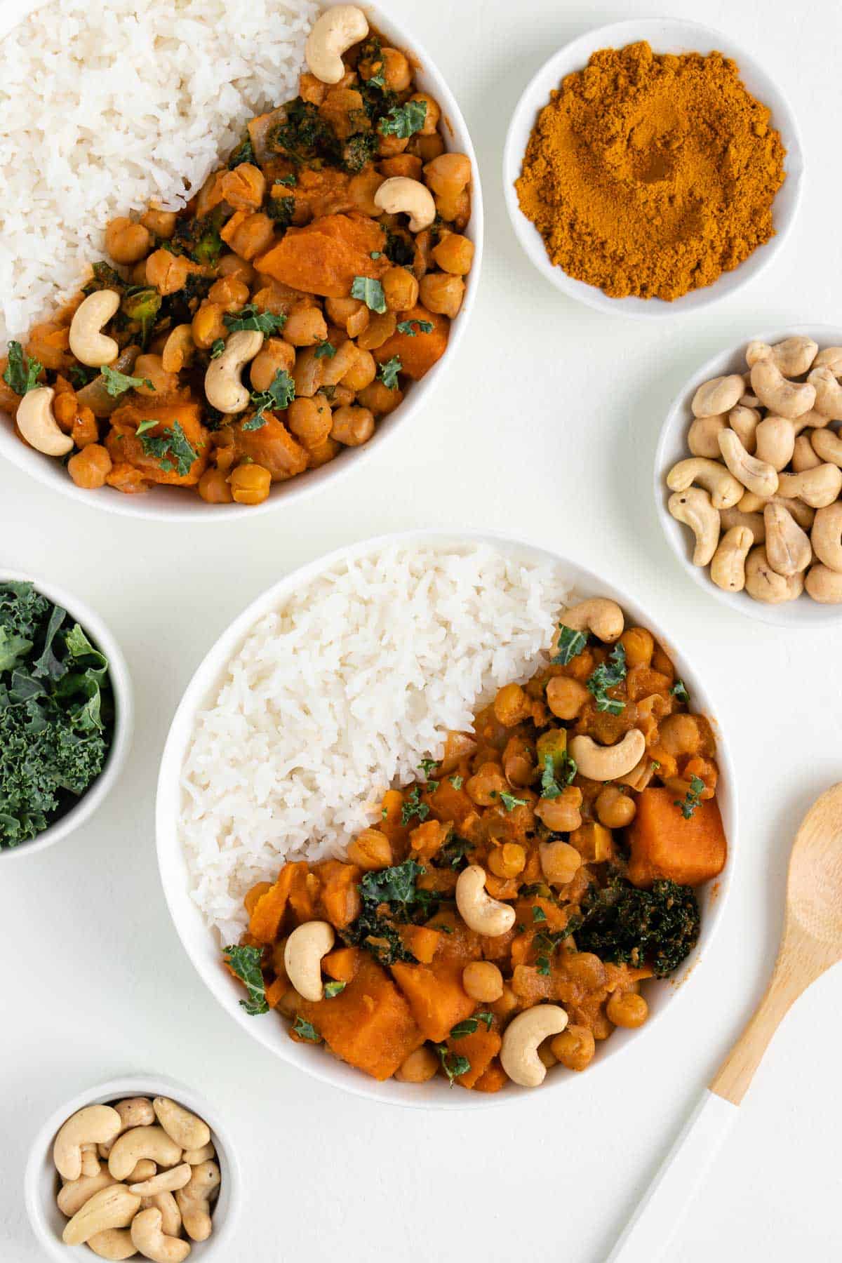 two bowls of white rice and sweet potato curry with chickpeas and kale