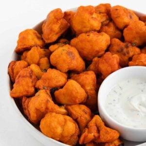 vegan buffalo cauliflower wings with dairy-free ranch dressing dip in a bowl