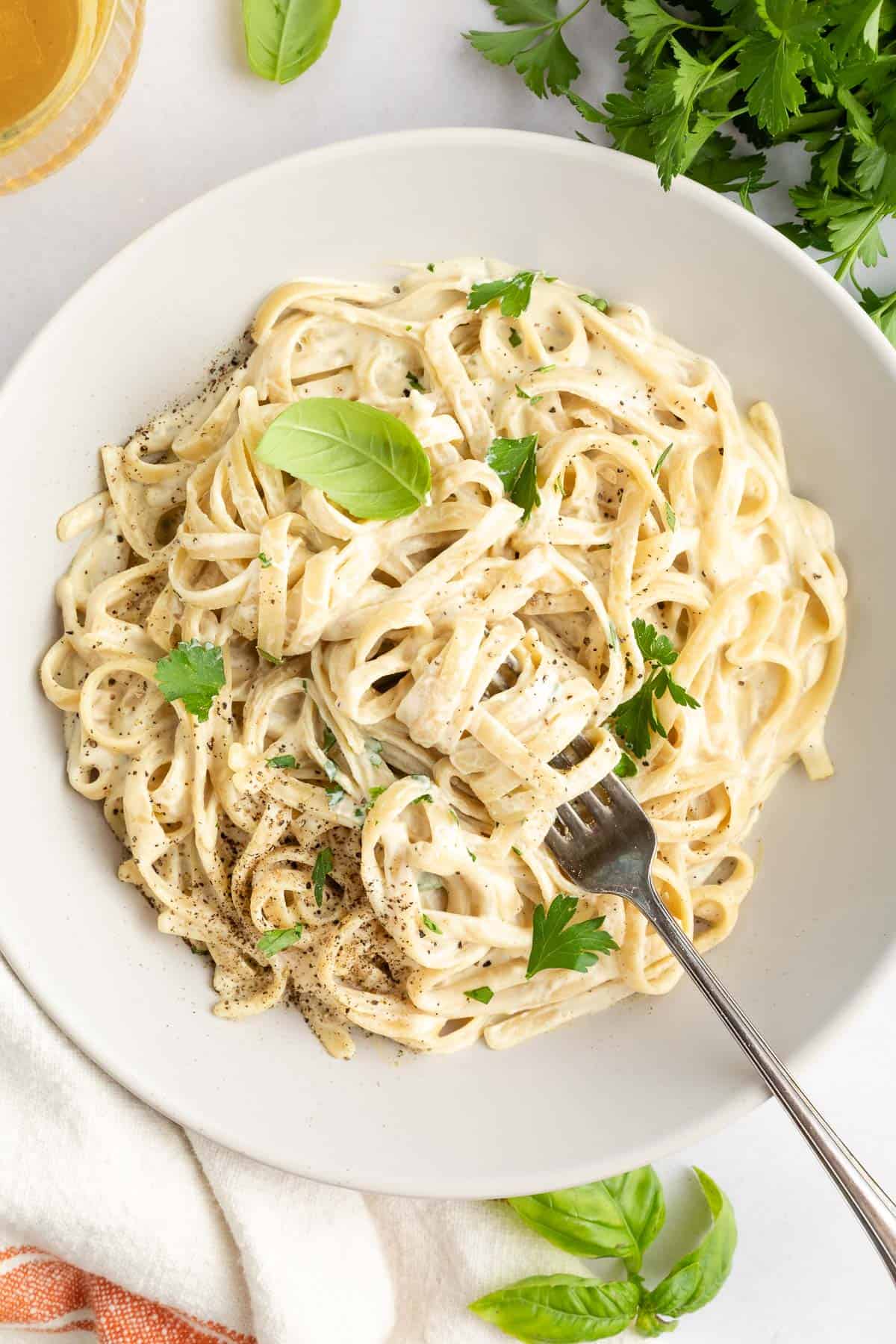 vegan fettuccine alfredo pasta inside two white bowls