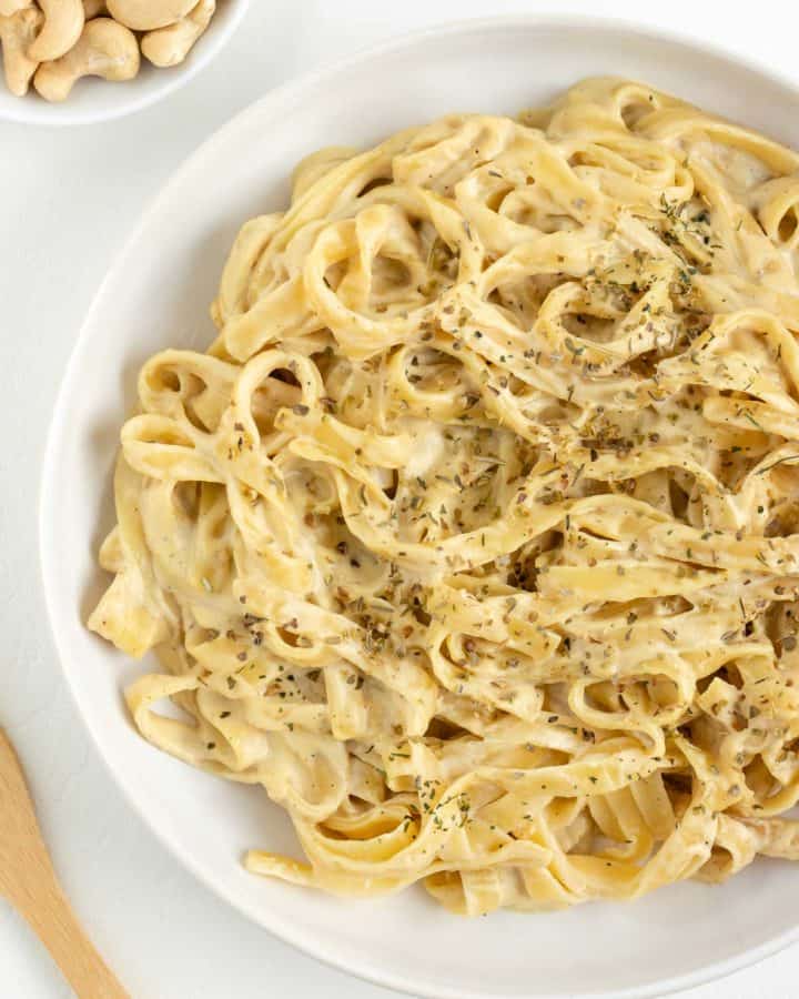 vegan fettuccine alfredo pasta inside a white bowl