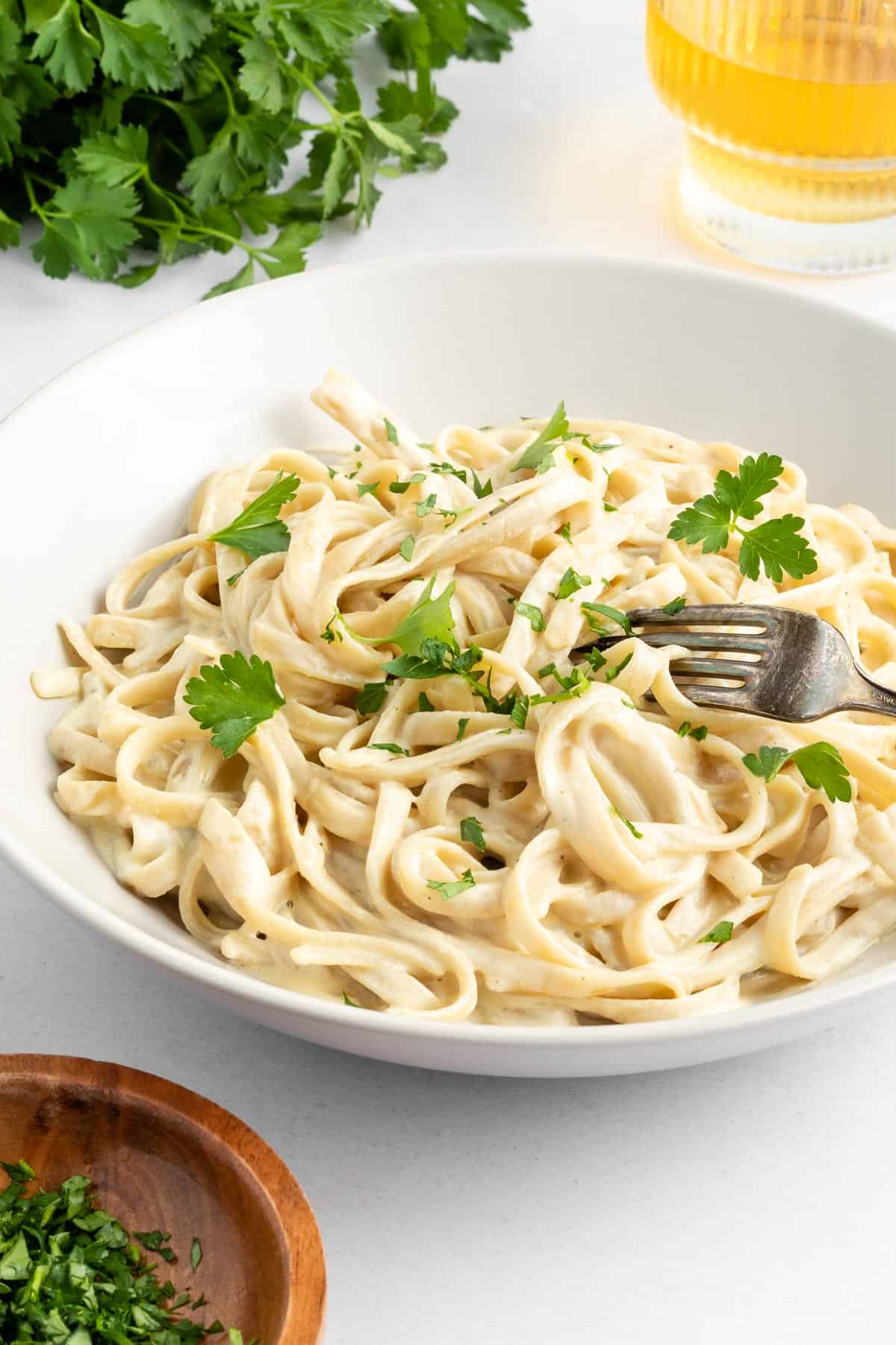 vegan fettuccine alfredo pasta inside a white bowl