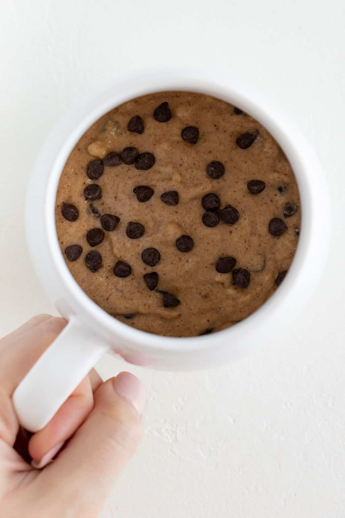 chocolate chip banana bread batter inside a white mug