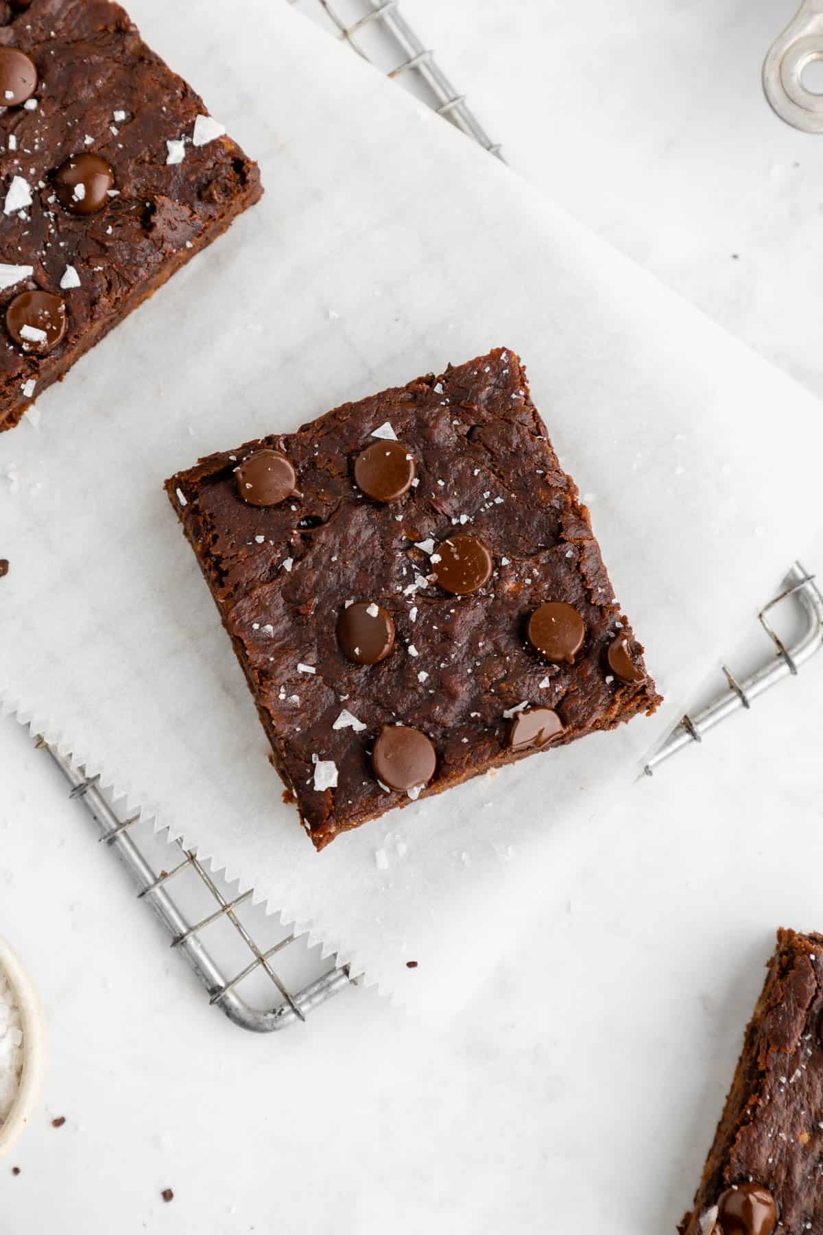 a hand holding a stack of three vegan protein brownies